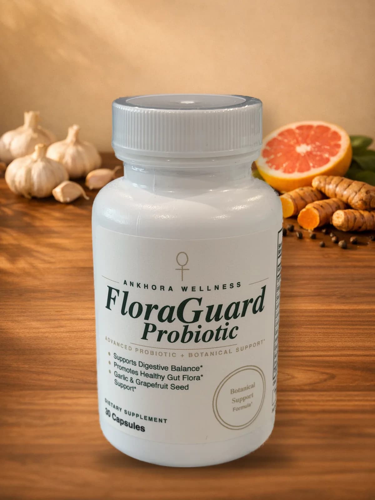 FloraGuard Probiotic bottle — 30 capsules, front label — with fresh garlic, halved grapefruit, turmeric root, and black peppercorns on warm walnut wood in golden-hour light